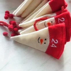 Adventskalender|Evas Vintage Adventskalender aus Filzmützen mit stilisiertem Schneemann-Gesicht