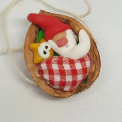 Baumschmuck|Danielas IdeenReich Baumschmuck Walnussschale Schaukelbettchen mit kleinem schlafend Wichtel mit roter Zipfelmütze und kleinem Stern