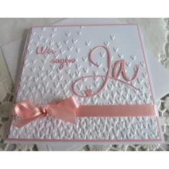 Einladungskarten|IdeenOase Einladungskarte zur Hochzeit in weiß/rosa, mit geprägtem Hintergrund, und *Wir sagen Ja* Schriftzug