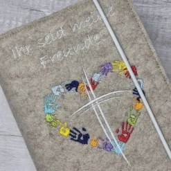 Discount Gotteslobhülle Ihr seid meine Freunde, Kreuz mit Herz aus Händen; beige Gotteslobhülle